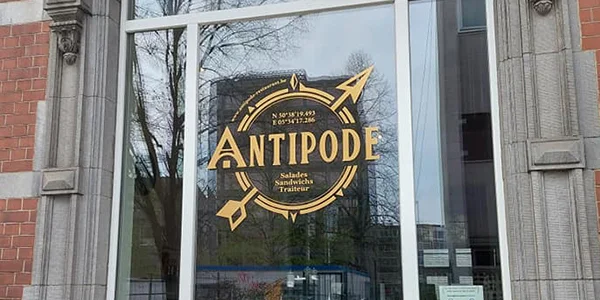 Vitrine de la sandwicherie Antipode, logo et nom en lettrage doré
